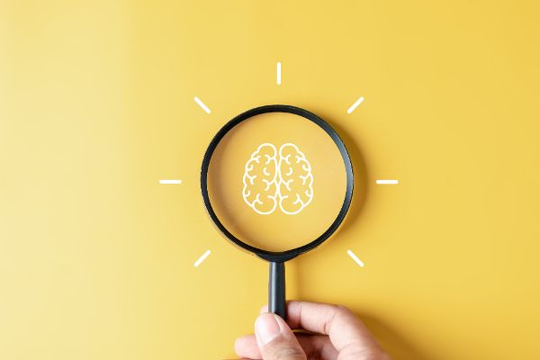 Lupe mit Brainstorming im Inneren für klug, Idee, kreativ, Denken; Bildung, Innovation, intelligentes Intelligenzkonzept.