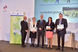 Bild zeigt ein Bühnenfoto mit Mario Wintschnig von der siegreichen Zumtobel AG zusammen mit Joseph Delia (Arbeitgebervertretung Maltas), Dr. Christa Sedlatschek (EU-OSHA), Stefan Olsson (Europäische Kommission), Mag. Martina Häckel-Bucher (BMASK) auf der Bühne