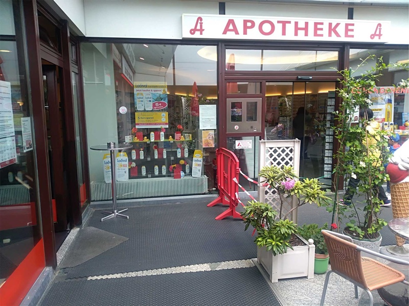 Zwei nebeneinanderliegende Geschäfte definieren mit Hinweisschildern Zugänge, um den Kundenstrom zu regeln und einen geordneten Zugang zu ermöglichen.